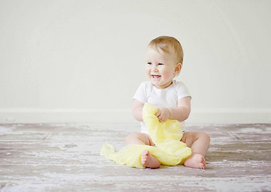 Happy Baby Playing with Yellow Fabric