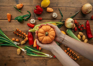 Pumpkin held in hands on wooden table