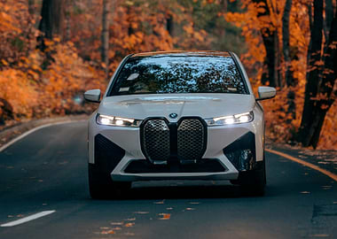 White BMW iX on Autumn Road