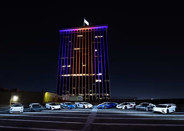 Luxury Cars at Night with Skyscraper