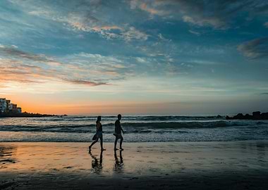 Couple walking on beach at sunset