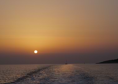 Sunset over the sea with boats in Greece