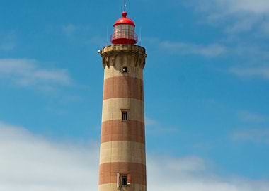 Striped Lighthouse Against Blue Sky