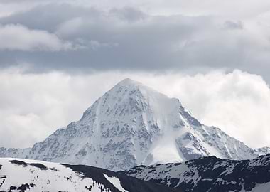 Snowy Mountain Peak Under Cloudy Sky