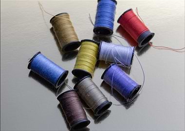 Colorful Thread Spools on Reflective Surface