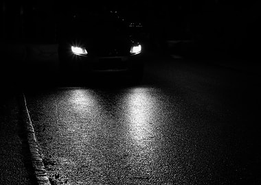 Car headlights on wet road at night