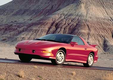 Red Pontiac Firebird in Desert Landscape