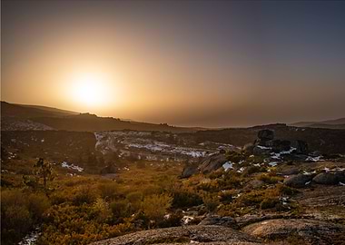 Sunset over rocky, snowy landscape
