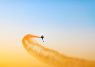 Aerobatic Plane with Orange Smoke Trail