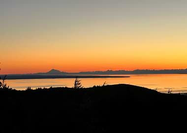 Sunset over water with mountain silhouette in Alaska