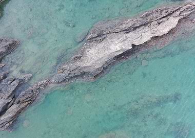 Aerial view of rocks in turquoise water