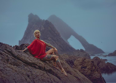 Tattooed Woman in Red on Rocks