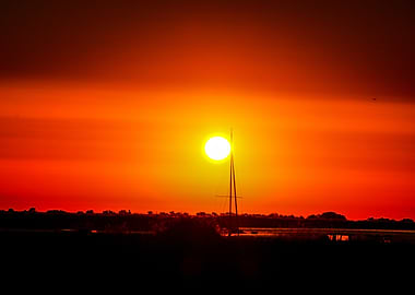 Vibrant Sunset with Sailboat Silhouette