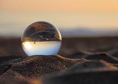 Crystal ball on beach at sunset