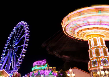 Ferris wheel and carousel spinning at night at 'Hamburger Dom'
