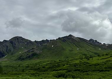 Green Mountain Range Under Cloudy Alaskan Sky