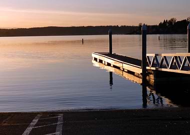 Dock on calm lake at sunset