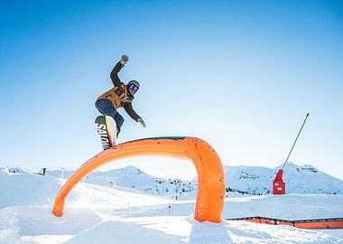 Snowboarder on Orange Rail in Snow Park