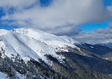 Snowy Mountain Range Under Cloudy Sky