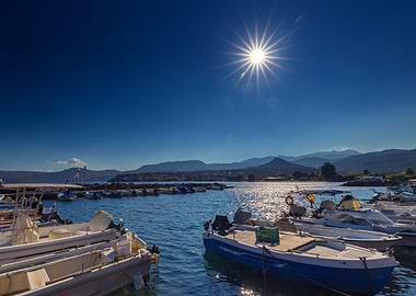 Boats in harbor under bright sun, Greek Island