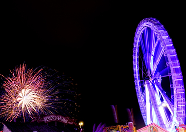 Ferris wheel and bright firework shells on the Hamburger Dom