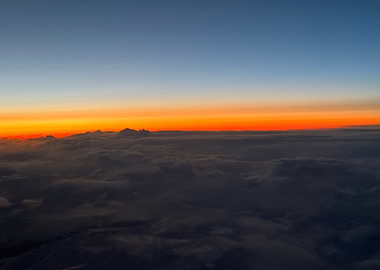 Aerial view of Denali at sunset over clouds
