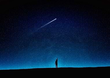 Silhouette under starry night with comet