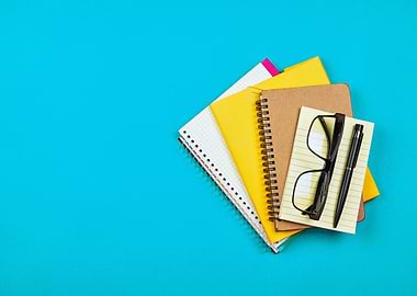 Notebooks, Glasses, and Pen on Blue Background