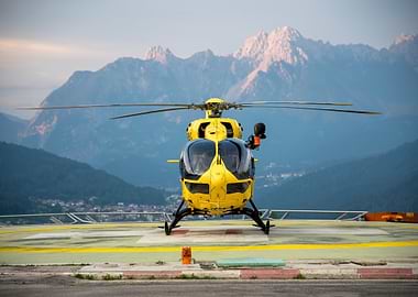 Yellow helicopter on helipad with mountains