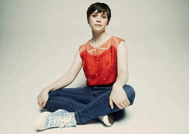 Sophia Lillis sitting cross-legged