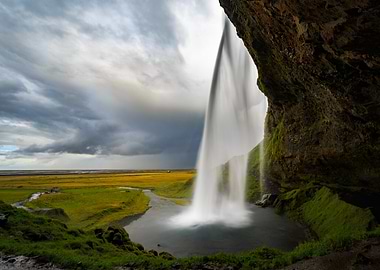 Iceland waterfall cascading into a pool with dramatic sky