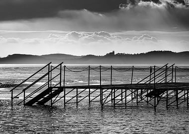 Pier on a Frozen Lake with Distant Hills