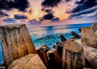 Dramatic Sunset Over Ocean with Breakwaters
