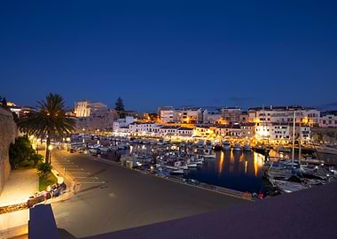 Nighttime harbor with boats and buildings