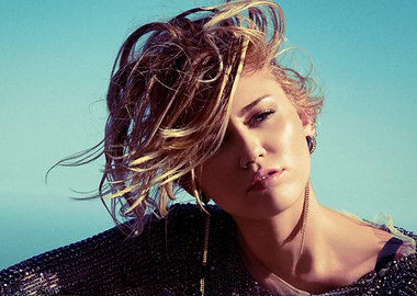 Miley Cyrus with windswept hair and sparkling jacket