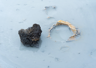 Rocks in a milky blue geothermal water