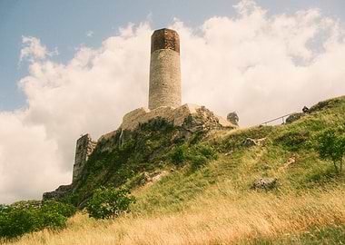 Ruins of a stone tower on a grassy hill