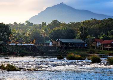 Laos River village at the foot of a misty mountain