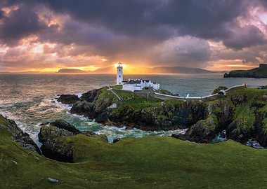 Lighthouse on a rocky island at sunset