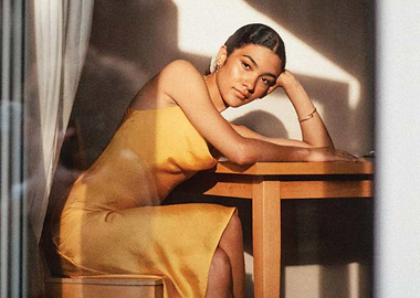 olivia dean in yellow dress by table