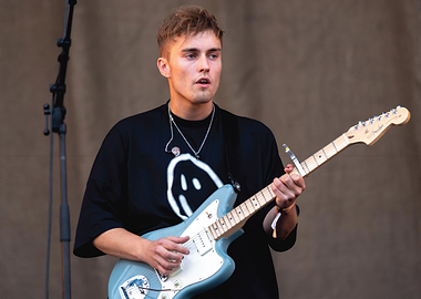 Musician playing a light blue electric guitar