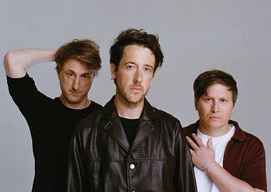 Three men posing for a photo the wombats