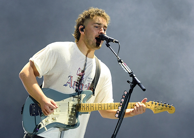 Musician playing guitar and singing Sam Fender