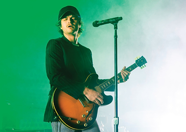 Musician playing guitar on stage djo joe keery