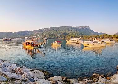 Boats in a clear blue bay at sunset