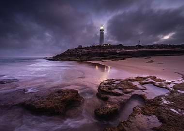 Lighthouse on a rocky coast at dusk