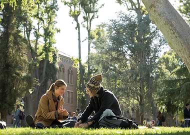 Couple sitting on grass on campus