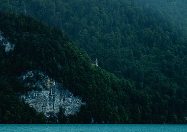 Castle on a forested mountainside overlooking water