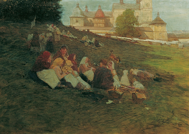 People picnicking on a grassy hill with a castle in the background