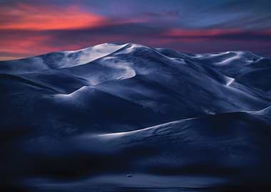 Snow-dusted desert dunes at twilight